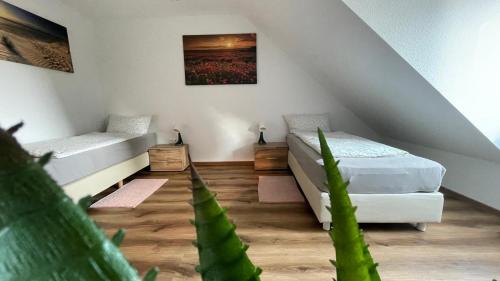 a attic room with two beds and a plant at Gavner Boardinghouse Apen in Apen