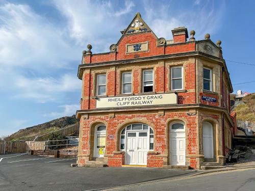 an old brick building with a sign on it at Cliff Railway Apartment in Aberystwyth