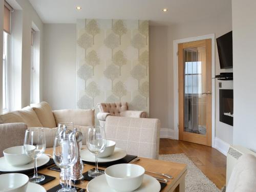 a living room with a table with wine glasses at Cliff Railway Apartment in Aberystwyth