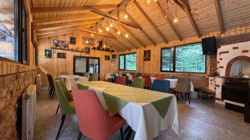 a restaurant with tables and chairs in a room at Conacul Dascălu in Trăisteni