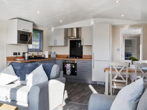 a kitchen and living room with a couch and a table at Lodge 10 Bridlington Holiday Park - Uk48212 in Carnaby