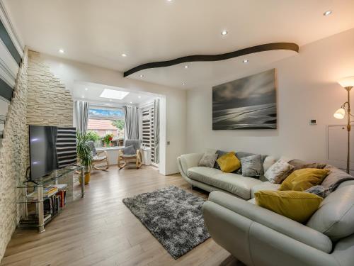 a living room with a couch and a tv at Cherrytrees in Scarborough
