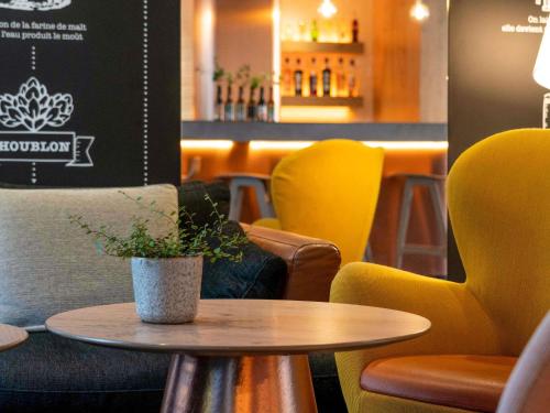 a table with a potted plant on it in a restaurant at Ibis Styles Colmar Centre in Colmar