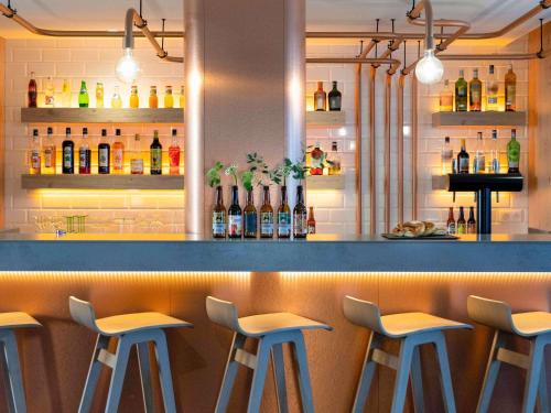 a bar with five bar stools in a restaurant at Ibis Styles Colmar Centre in Colmar