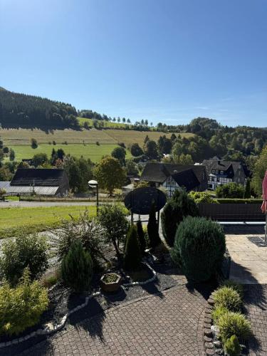 a patio with an umbrella and some bushes and houses at Haus Sonnenschein in Winterberg