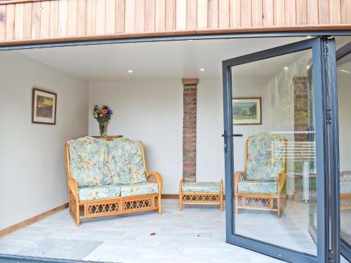 a room with two chairs and a glass door at Glen Rosa in Ayr