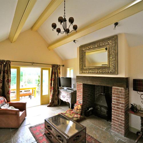 a living room with a fireplace with a mirror at Huckleberry Cottage at Black Horse Beamish in Beamish
