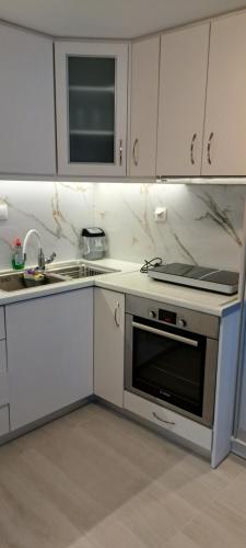 a kitchen with white cabinets and a stove top oven at Ανεμώνη Αράχωβα in Arachova