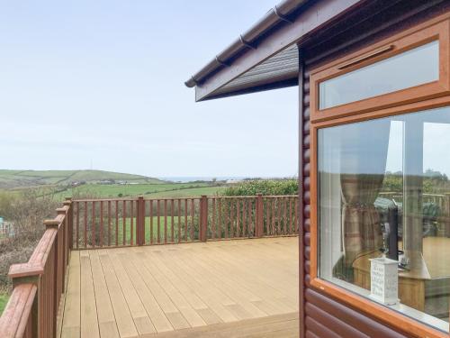 a wooden deck with a view of the hills at Grandma's Stick House in West Down