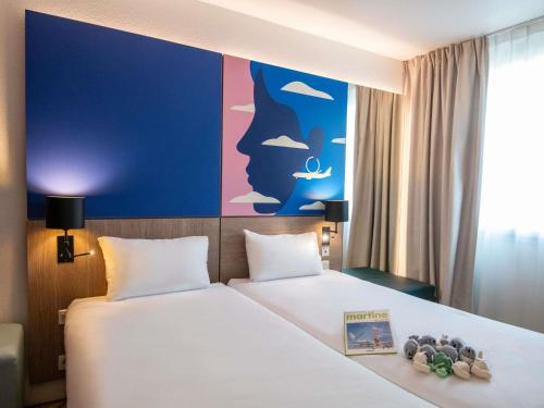 a hotel room with a bed with a book on it at ibis Styles Nice Aéroport Arenas in Nice
