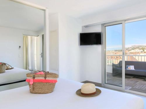 a hotel room with a bed and a hat on a table at Ibis Styles Menton Centre in Menton
