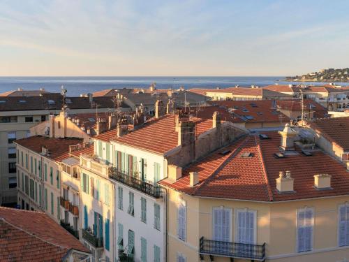 a view of roofs of buildings and the ocean at Ibis Styles Menton Centre in Menton