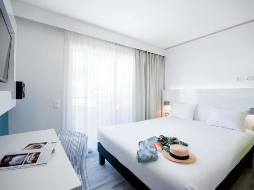 a hotel room with a bed with a hat on it at Ibis Styles Menton Centre in Menton