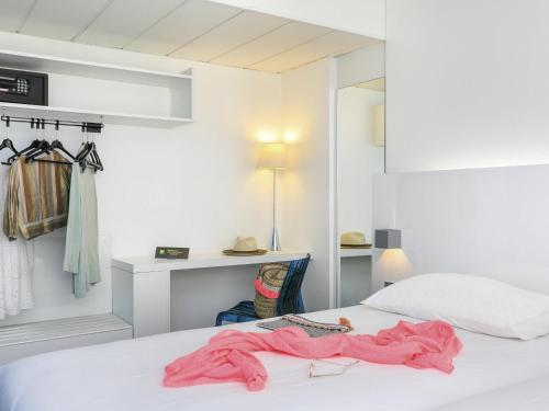 a bedroom with a bed with a pink robe on it at Ibis Styles Menton Centre in Menton