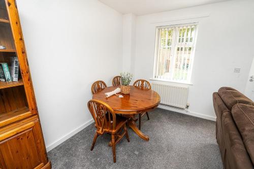 a dining room with a wooden table and chairs at Modern 2-Bed Home with Driveway – Basingstoke in Sherborne Saint John