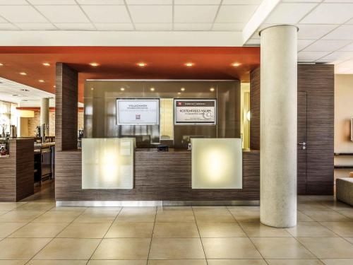 a lobby with a reception desk in a building at ibis Hotel Friedrichshafen Airport Messe in Friedrichshafen