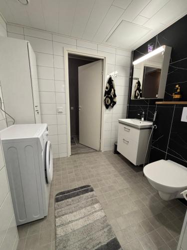 a bathroom with a toilet and a sink at Stylish two-rooms and kitchen apartment 66 m2 in Turku