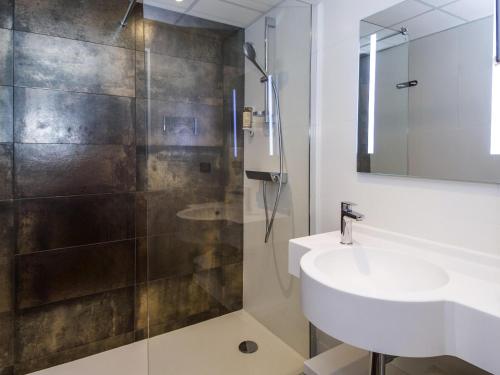 a bathroom with a sink and a shower at Hôtel Mercure Rodez Cathédrale in Rodez