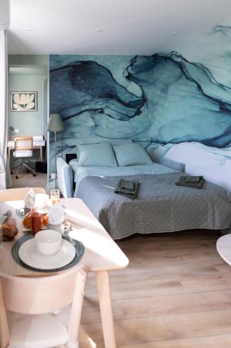 a bedroom with two beds and a table in front of it at Topa Casa Gîte d'hôtes à Creil in Creil