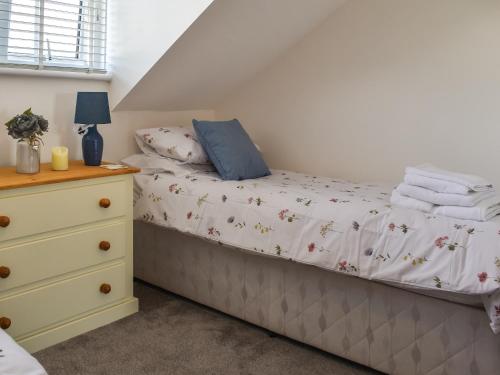 a bedroom with a bed and a dresser at Kingfishers Rest in Millom