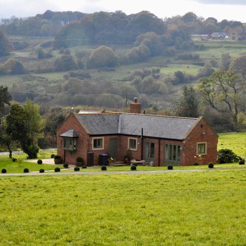 a house in the middle of a green field at Huckleberry Cottage at Black Horse Beamish in Beamish