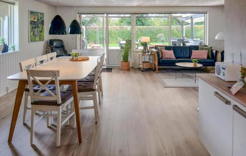 a kitchen and living room with a table and chairs at Nice Home In Tarm With Kitchen in Hemmet