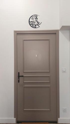 a door with a clock on top of it at Le Réverbère, appartement de vacances in Lectoure