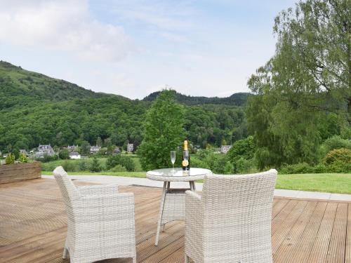 a table and chairs on a patio with a view at Fascadail-Uk34219 in Aberfoyle