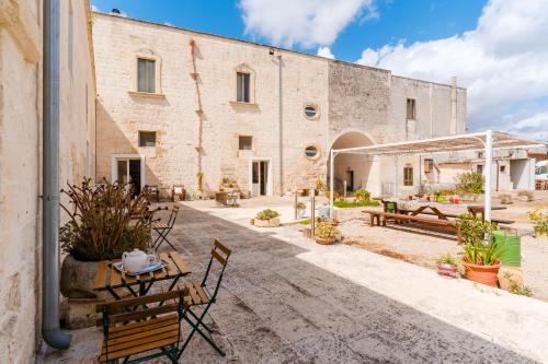 a courtyard of a building with a table and chairs at Masseria La Lizza - Ospitalità Rurale in Lecce