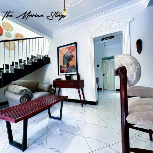 a living room with a couch and a table and a chair at The Marina Stays Private Hotel Spa Entebbe in Entebbe