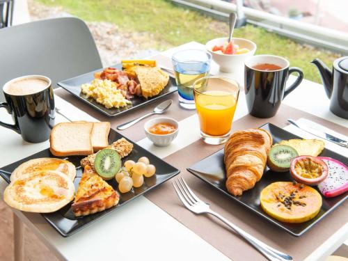 a table topped with plates of breakfast foods and drinks at Mercure Dieppe La Présidence in Dieppe