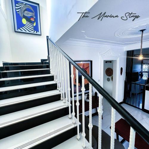 a staircase in a house with a sign on the wall at The Marina Stays Private Hotel Spa Entebbe in Entebbe