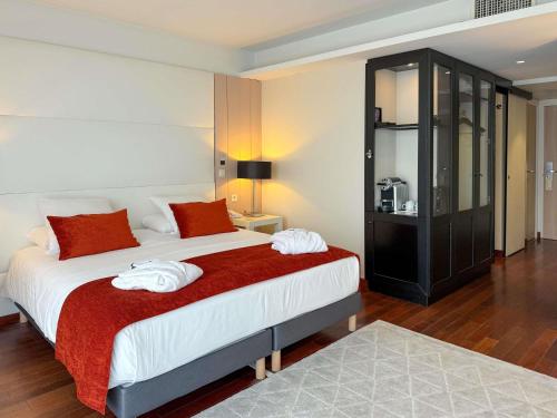 a bedroom with a large bed with red and white pillows at Mercure Dieppe La Présidence in Dieppe