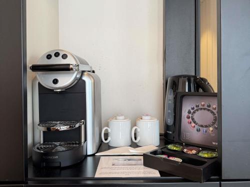 a kitchen counter with a coffee maker and a mixer at Mercure Dieppe La Présidence in Dieppe