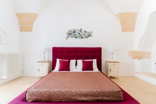 a large bed with a red headboard in a bedroom at Masseria La Lizza - Ospitalità Rurale in Lecce