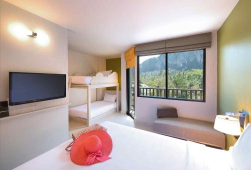 a living room with a television and a large window at ibis Styles Krabi Ao Nang in Ao Nang Beach
