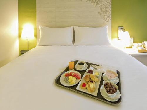 a tray of food sitting on top of a bed at ibis Styles Krabi Ao Nang in Ao Nang Beach