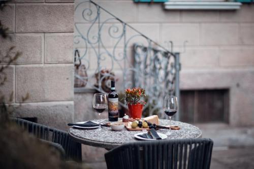 a table with wine glasses and a plate of food at Villa Elisabetta Lago Maggiore in Belgirate