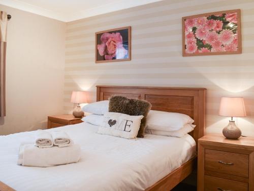 a bedroom with a large white bed with two lamps at 7 Oaklands in Ambleside