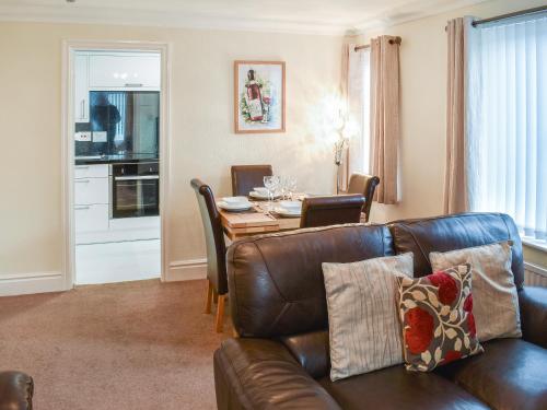 a living room with a leather couch and a table at 7 Oaklands in Ambleside