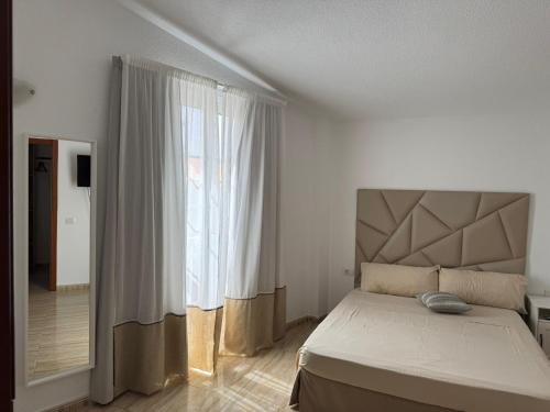 a bedroom with a bed and a large window at Tulum Airostel in San Isidro