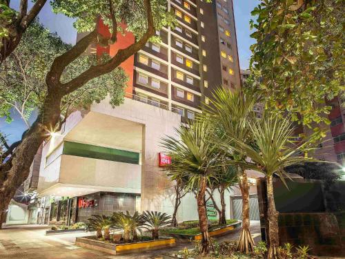 un bâtiment avec des palmiers devant dans l'établissement Ibis Belo Horizonte Savassi, à Belo Horizonte