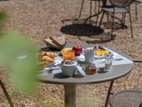 a table with a tray of breakfast food on it at Mercure Aix-En-Provence Sainte-Victoire in Châteauneuf-le-Rouge
