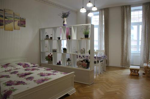 a bedroom with a bed and a white shelf with plants at ABC Homestay in Golčŭv Jeníkov