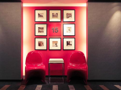 a room with two red chairs and a table at Mercure Sapporo in Sapporo