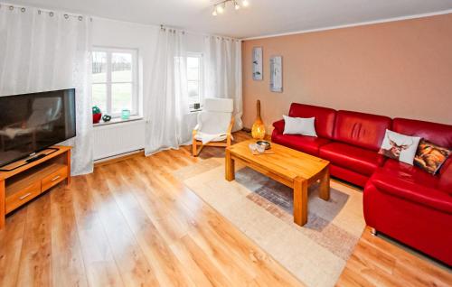 un salon avec un canapé rouge et une table dans l'établissement Ferienwohnung Userin, à Userin