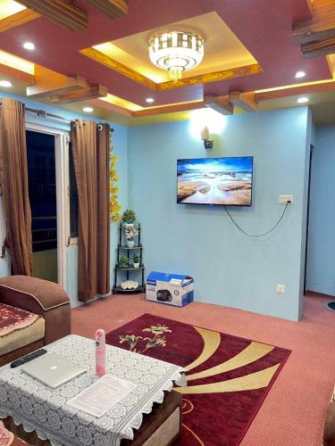 a living room with a table and a laptop on the wall at Mountain view Escape in Kathmandu