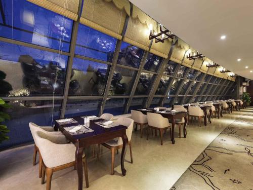 a row of tables and chairs in a restaurant at Pullman Beijing South in Daxing
