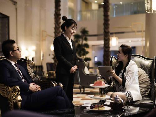 three people sitting around a table in a room at Pullman Beijing South in Daxing