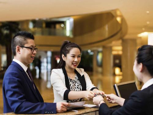 a group of people shaking hands at a table at Pullman Beijing South in Daxing